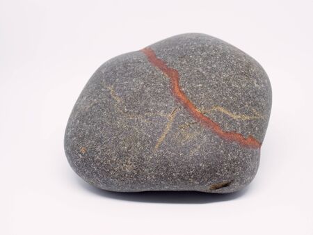 Isolated rounded stone with mineral veins.  Stone brown with white veins isolate on a white...