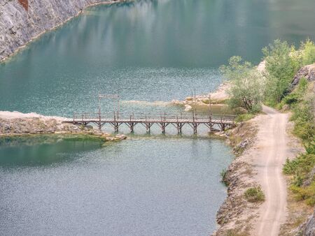 Green blue lake with wooden tourist path bridge above cold water. Hiking in the national parkの写真素材