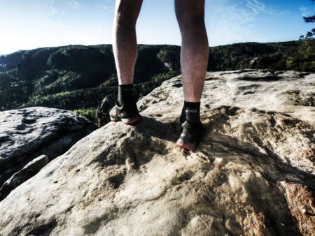 Sportsman on trail. Slim body man in yellow jersey, black shorts and running shoes run in wild nature. Abstract filter.の写真素材