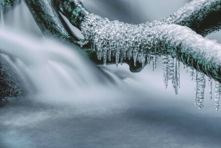 Iced water on a small river stream in a forest on a cold autumn day
