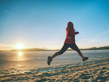 Woman jogging on winter beach run. Female athlete runner jogger training living healthy active exercise lifestyle exercising outdoor on beachの写真素材