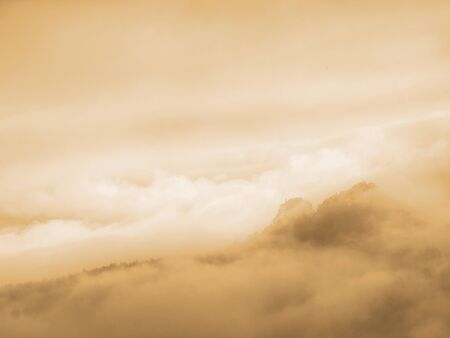 Mist in hilly landscape. Autumn creamy fog in countryside. Hill increased from fog the fog is...