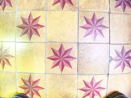 Horizontal tiled floor in old burgher house in detail. Tiles red and white stars