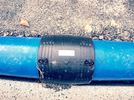 Welded black joint between two blue HDPE tubes for drink water delivery. Repairing of water supply system.の写真素材