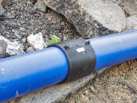 Welded black joint between two blue HDPE tubes for drink water delivery. Repairing of water supply system.の写真素材
