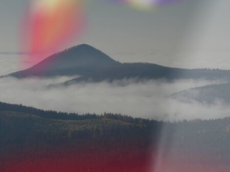 Dreamy misty landscape above the sea of clouds, high peaks at horizon