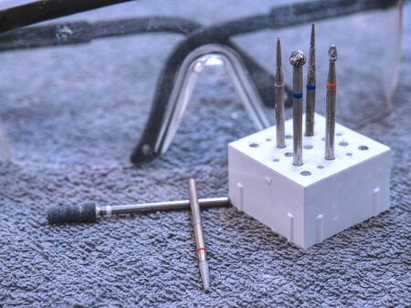 Detail of tools in modern dental clinic office with dental treatment tools. Focus on medical instruments, tablet and glasses on table of stomatologistの写真素材