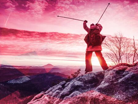 Lone figure watches the sunset from sharp rock looking down at the valley.  Abstract filter.の写真素材