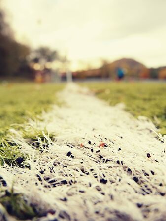 Turf playground with lines and cones, soccer players out of focus training slalom drills on soccer...