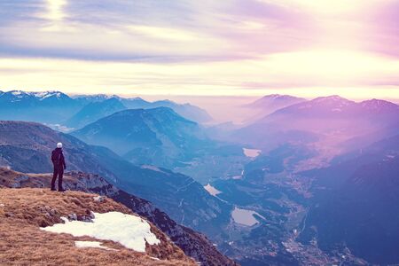 Man hiker reach the mountain edge and watch the deep valley bellow. Amazing far view over landscape.