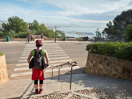 Woman backpacker walk down from old castle. Stony staircase bellow stronghold, Castell de Bellver,...