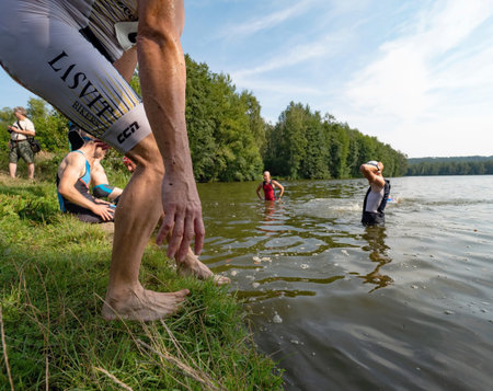 Man jumping down into water. Start of race. Amateur SAMUEL XC triathlon Radvanec, Czech Republic.   23th of August 2019のeditorial素材