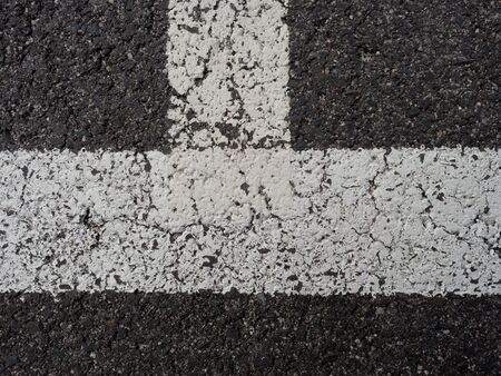 White paint line on old obsolete asphalt plaground. Empty kids areal.