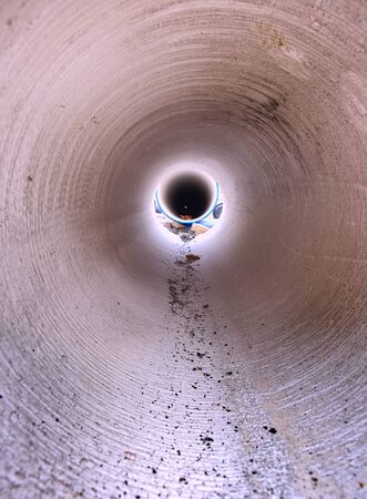 Looking inside of the large diameter HDPE pipe for potable water supply. Repairing of water delivery system in townの写真素材