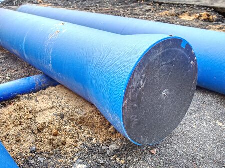 Pipes on building site ready for using underground. New pipeline for water delivery