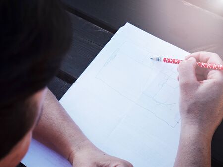 Woman drawing flat sketch. Pencil In Women Hand Writing On Paper.