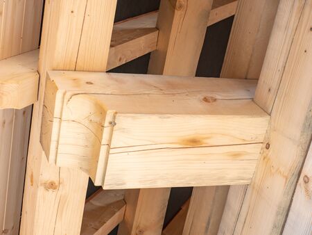 Roofing construction with wooden beams, low angle view. Big spruce logs, rafters, trusses.