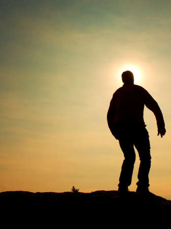 Man ready to jump. Adult crazy man is jumping on colorful sky background.Silhouette of man and...