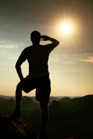 Hiker stands on peak of sandstone rock in rock empires park and watching over the misty and foggy morning valley to Sun. Beautiful moment the miracle of natureの写真素材