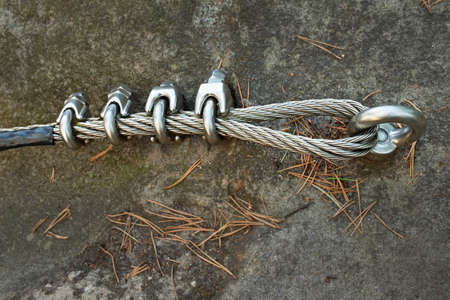 Mountain wall with carabine in the rock. End of the iron rope in loop.の写真素材