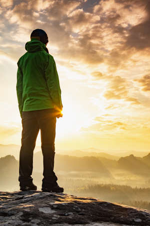 Young woman climb the top in the mist at dawn on the mountain top ofの写真素材