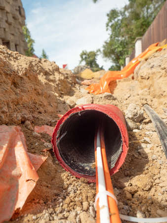 Data fiber optic cables in ribbed pipe under road. Wire in HDPE and protectivep tube. Building of...