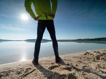 Morning workout. Warming up before training. Sportsman in sportswear doing stretching on the beach at sunriseの写真素材