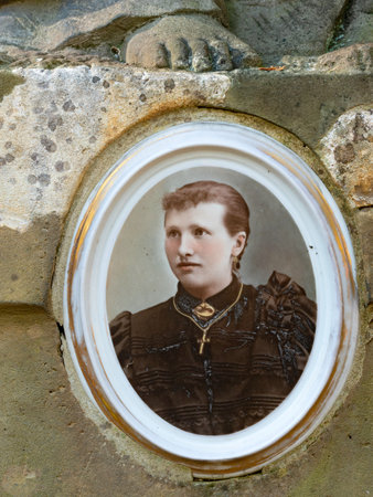 Tombstone with picture of nice young lady deid in 19th century. 24th of October 2020. Hronov, Czechia. Heloween walk in old town graveyardのeditorial素材