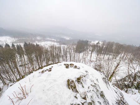 Volcano rock formation Zlaty vrch built pentagonal and hexagonal basalt columns. Looks like giant organ pipes. Covered by snow and ice in winter timeの写真素材