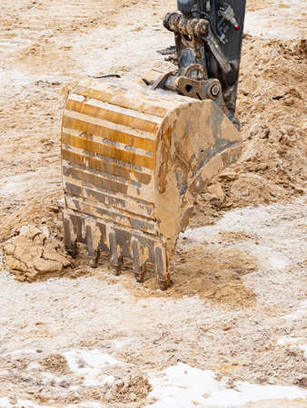 Detail of an excavator bucket. Backhoe bucket digging the soil. Crawler excavator digging at shale...