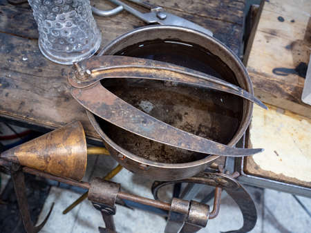 Soffieta, outside caliper and cutting edge scissors on the glass blowing master tools table. Every glassblowers has his favorite set of own tools which he uses when creating design pieces.の写真素材