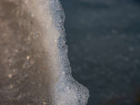Smashed ice melts in the water on the edge of the beach. Large icebergs break, the problem of...