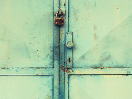 Vintage industrial metal door gate with obsolete locking system. Old green painted sheet iron, metal...