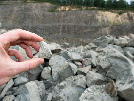 Hand hold stone or nugget in open quarry. Expert found the mineral source place