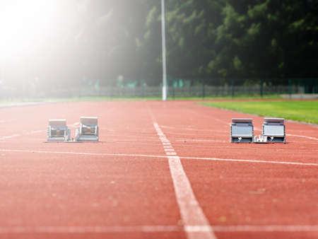 Starting blocks on red running tracks, light reflection an lens flare. Running trainingの写真素材