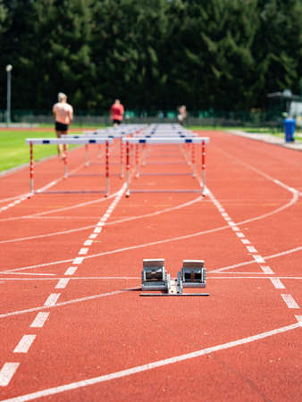 Obstacle course training. Athletics Starting Blocks and red running tracks in a stadiumの写真素材