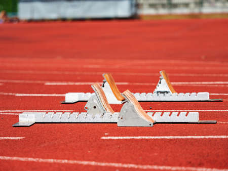 Close view to run start blocks ready on stadium tracks. Metal frame runner support