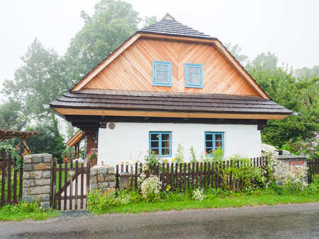Lichnice village, Czechia. 26th of August 2021. Restored historic timbered cottage with a layer of clay on the peripheral wall, the so-called fur coat. Classic shingle roof.の写真素材