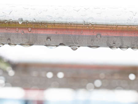 Close up of raindrops on a stainless steel bar. Chrome steel construction on workout placeの写真素材