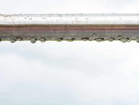 Close up of raindrops on a stainless steel bar. Chrome steel construction on workout place