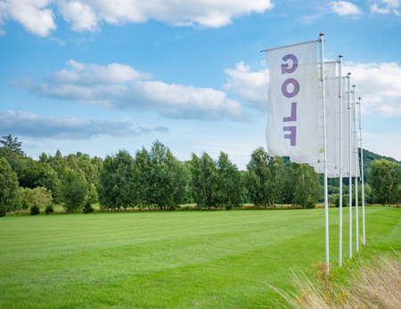 Flags at driving range for practicing golf swing. Nice landscape in sunny day with strong wind.の写真素材