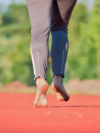 Bare feet female fitness model run and jog workout. Sports lifestyle concept. Stretching naked feet...