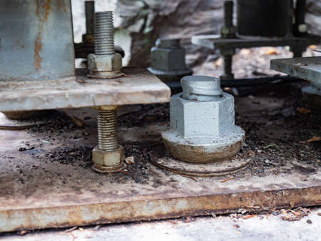 Bridging joint of girder bridge with concrete base in ground. Wooden cover, steel plates, screws and...