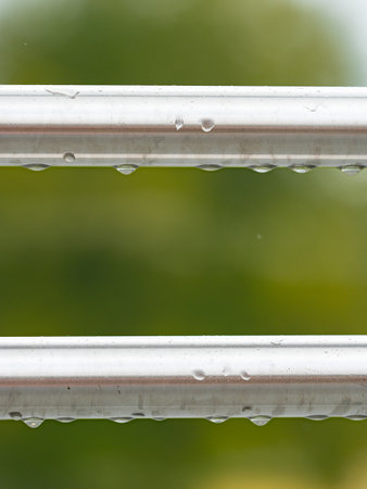 Fitness bars on workout gym place. Sport and training equipment. Parallel stainless bars outdoors with raindropsの写真素材