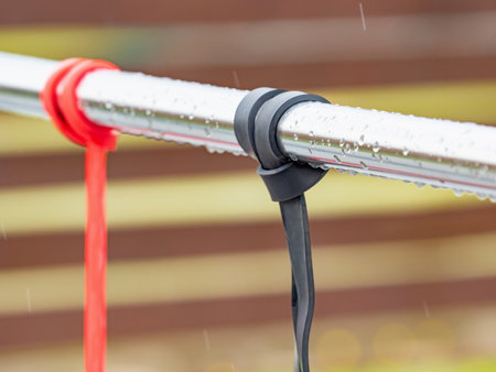 Exercise and stretching rubber elastic bands hanging on a workout rail. Exercise equipment after the rain without peopleの写真素材