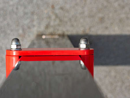 Red horizontal bar screwed with painted vertical frame construction. Exercise machines and fitness equipment for sports workout in the outdoor gymの写真素材