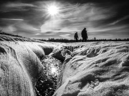 Unrecognizable people walking through snow mountain. Snowy park, winter walk. Natural background, selective focus. BW, Black and white,の写真素材