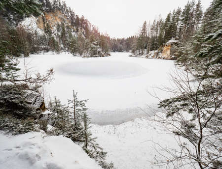 Frozen blue lake in Adrspach natural park. Winter hiking in popular in rocky labyrinth in Czech Republicの写真素材