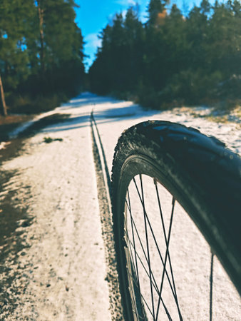 Rear wheel of mountain bicycle in snowy meadow in the countryside. Detail of the mountain bike. Extreme sports backgrounds.の写真素材