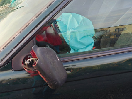 Deflated airbags after the erupted inflation due to a car collision. Car crash and airbag worked well. View through closed window. Broken rearview mirrorの写真素材